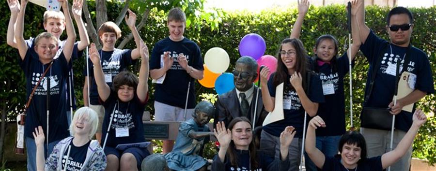Students who are blind around a statue.